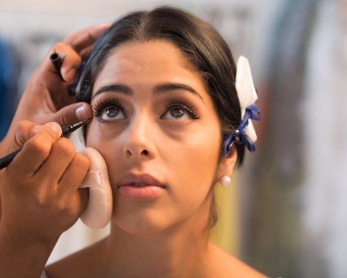 Close-up image of artist applying black eyeliner to lower lash line